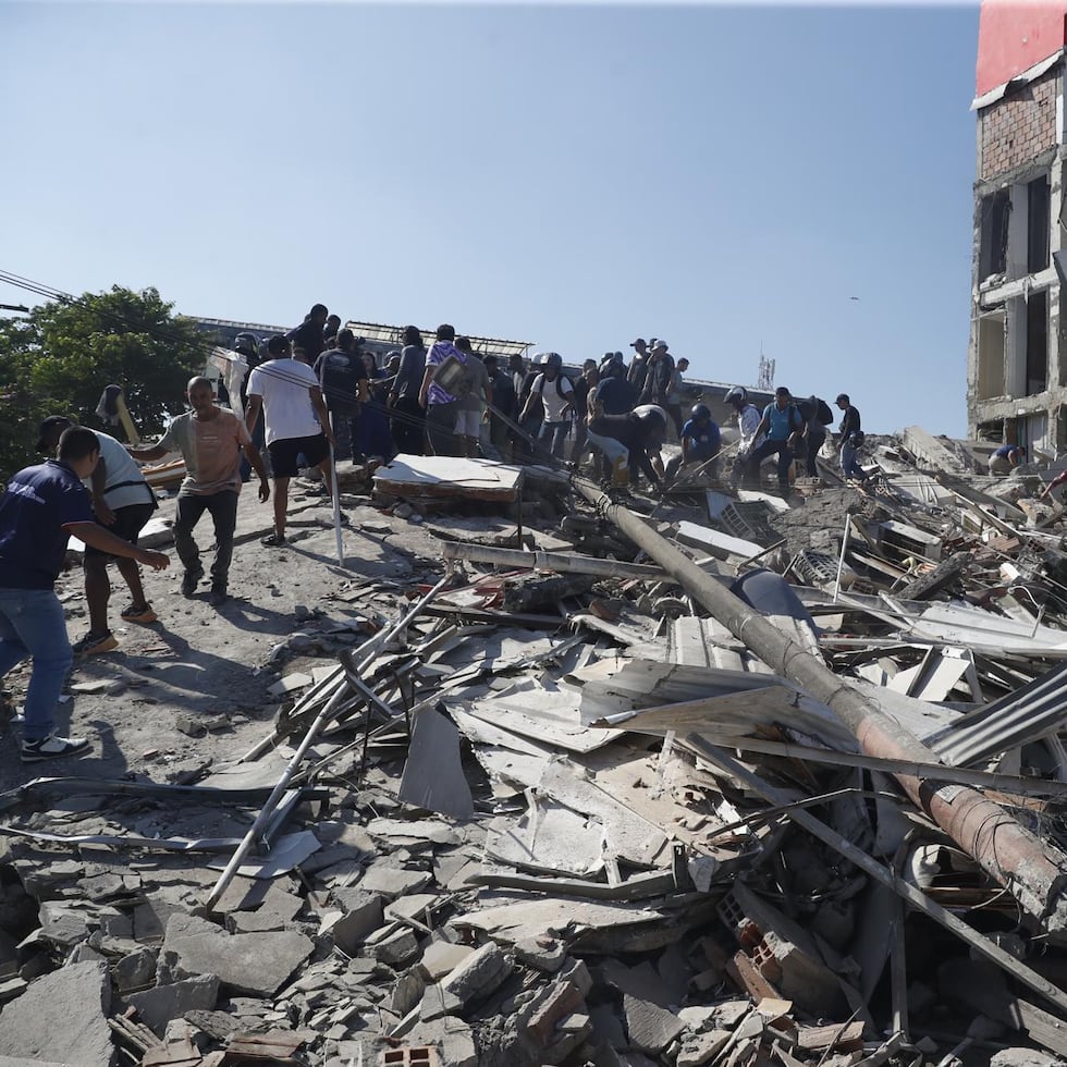 Las personas caminan sobre los escombros en la ciudad de Cali, en Colombia, tras el sismo.
