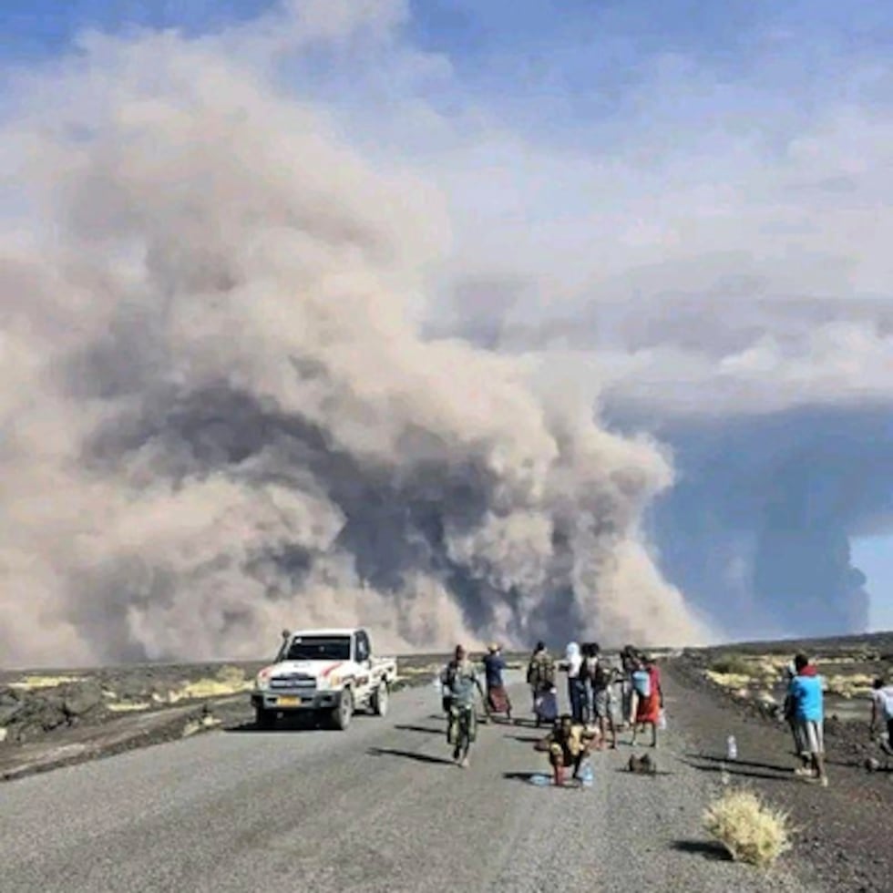 En esta foto publicada por la Oficina de Comunicación del Gobierno de Afar, varias personas observan las nubes de ceniza tras la primera erupción del volcán Hayli Gubbi, en la región etíope de Afar, el domingo 23 de noviembre de 2025. (Oficina de Comunicación del Gobierno de Afar vía AP)
