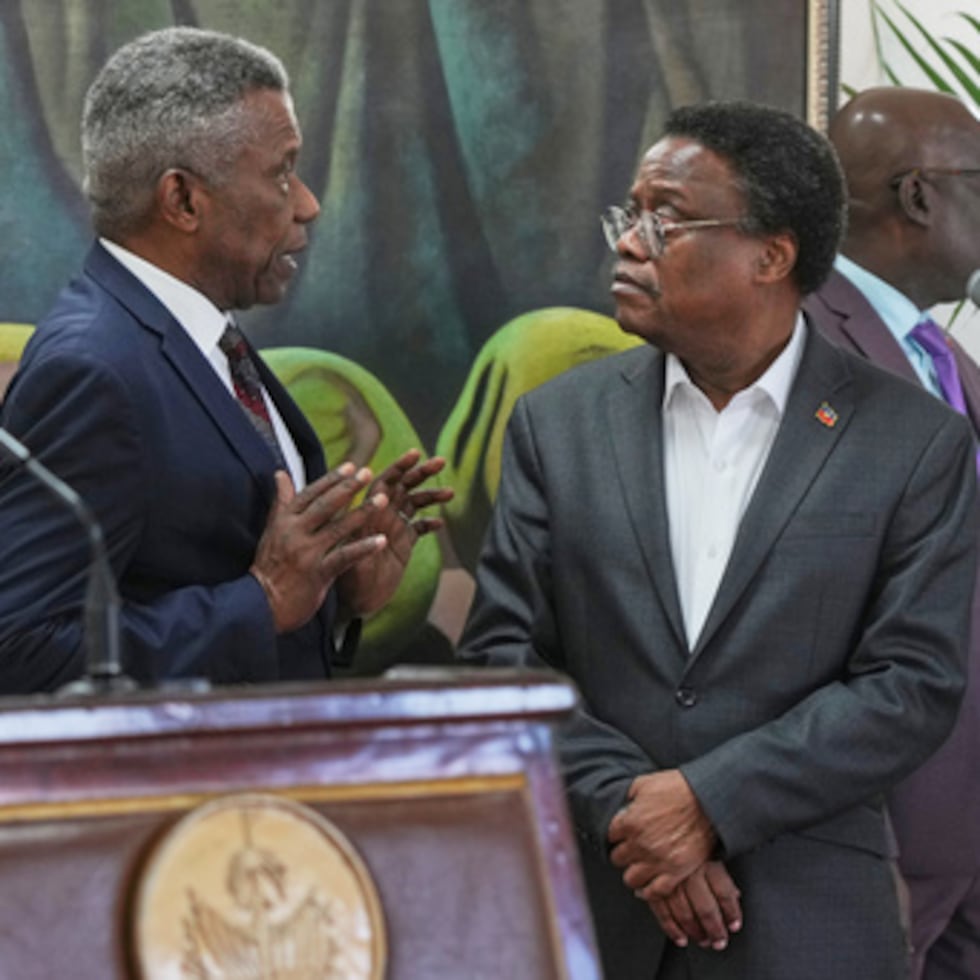 El Jefe de Protocolo del Palacio Nacional, Marc Marie Yves Mazile, habla con Fritz Alphonse Jean, miembro del consejo presidencial de transición de Haití, antes del inicio de una conferencia de prensa en Puerto Príncipe, Haití, martes 25 de noviembre de 2025. (AP Photo/Odelyn Joseph)