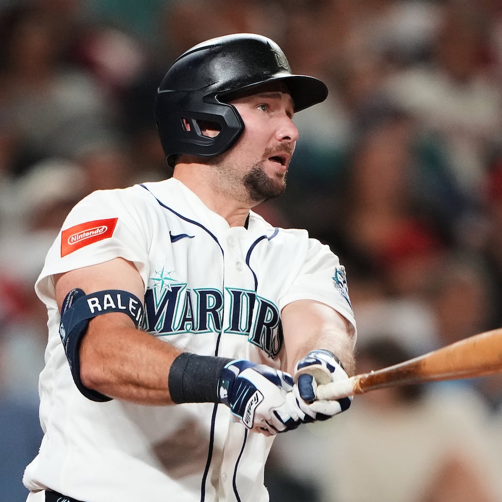Cal Raleigh, de los Mariners de Seattle, sigue el vuelo de la pelota que conectó de cuadrangular solitario en la séptima entrada.