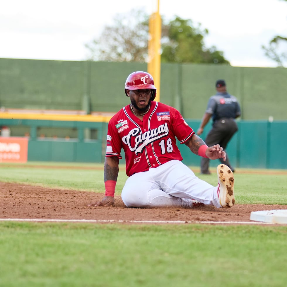 Nelson Velázquez, de los Criollos, se desliza en tercera base.