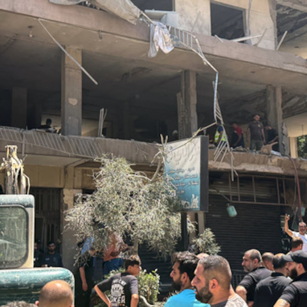 Varias personas se reúnen en el lugar donde un ataque aéreo israelí alcanzó un edificio de apartamentos en Dahiyeh, en los suburbios del sur de Beirut, en el Líbano.