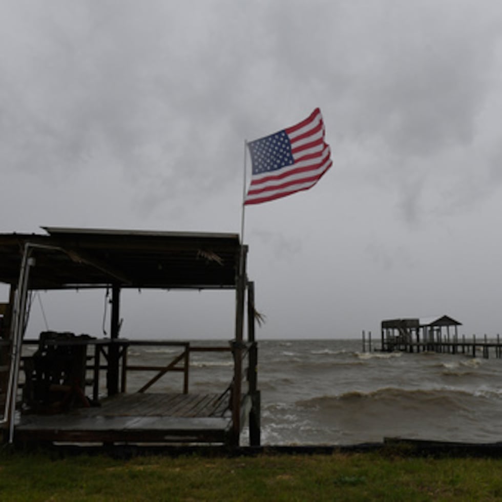 Una bandera estadounidense ondea con el viento provocado por los efectos de Isaias en una playa desierta el viernes 9 de octubre de 2026, en la isla Mon Louis, Alabama.