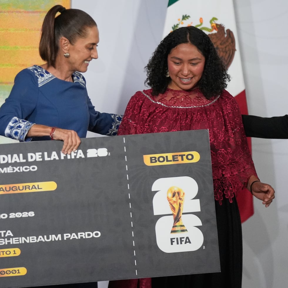 La presidenta mexicana Claudia Sheinbaum entrega un boleto simbólico para el partido inaugural del Mundial 2026 a la jugadora amateur Yolett Cervantes.