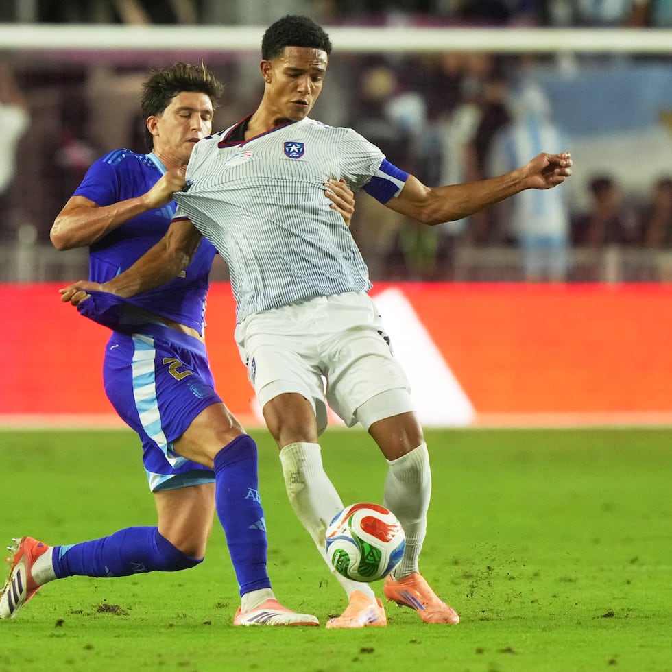 Leonardo Balerdi (2) agarra la camiseta al boricua Leandro Antonetti en defensa durante la segunda mitad del choque amistoso.