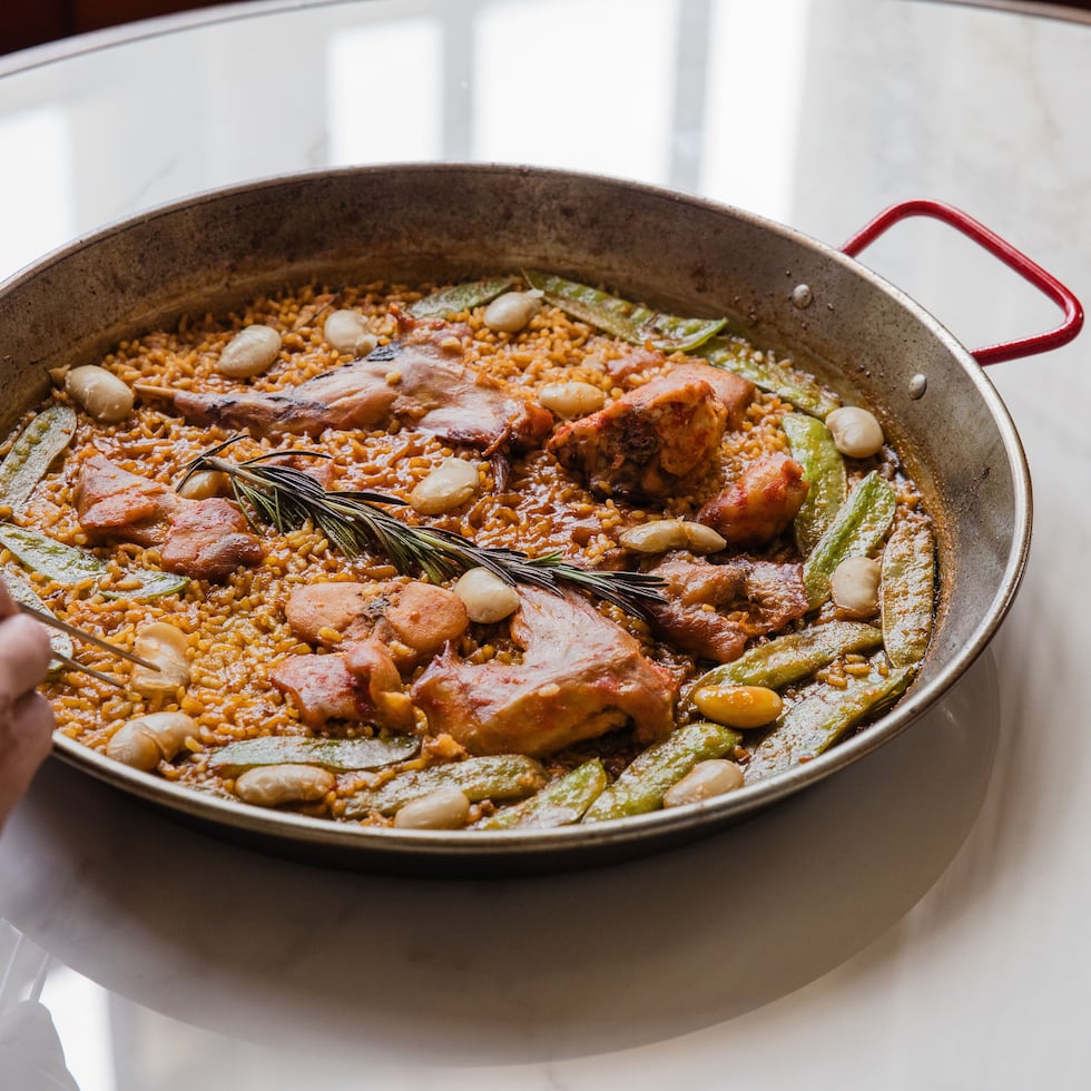 Una auténtica Paella Valenciana con pollo, conejo, vegetales de temporada y caldo de arroz con azafrán.