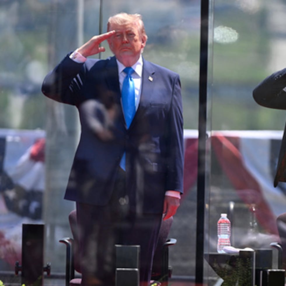 El presidente de Estados Unidos, Donald Trump,y el secretario de Seguridad Nacional Markwayne Mullin, derecha, saludan al inicio de la ceremonia de graduación en la Academia de la Guardia Costera de Estados Unidos en New London, Connecticut.