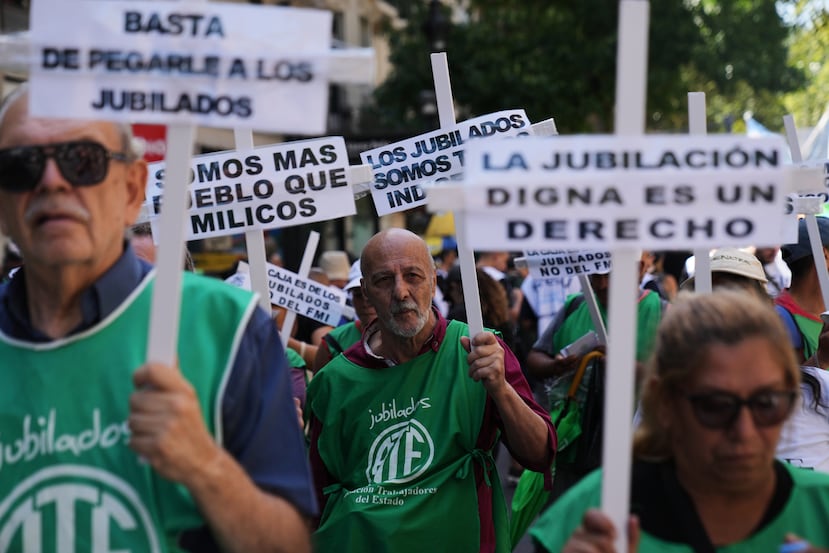 Demonstrators rally outside Congress with signs in defense of retired people during a protest against a labor reform bill proposed by President Javier Milei's government in Buenos Aires, Argentina, Friday, Feb. 27, 2026. (AP Photo/Rodrigo Abd)
