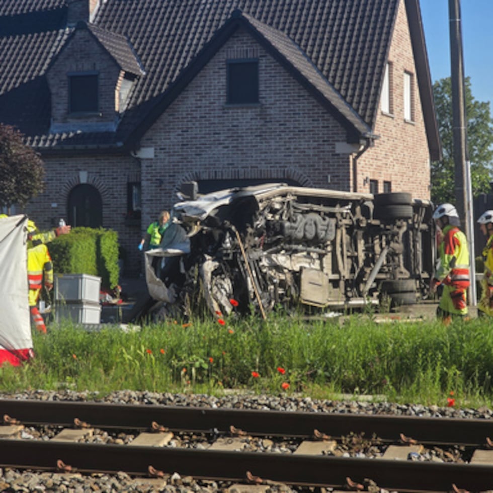 Rescatistas en el lugar de un choque entre un tren y un autobús escolar en Buggenhout.