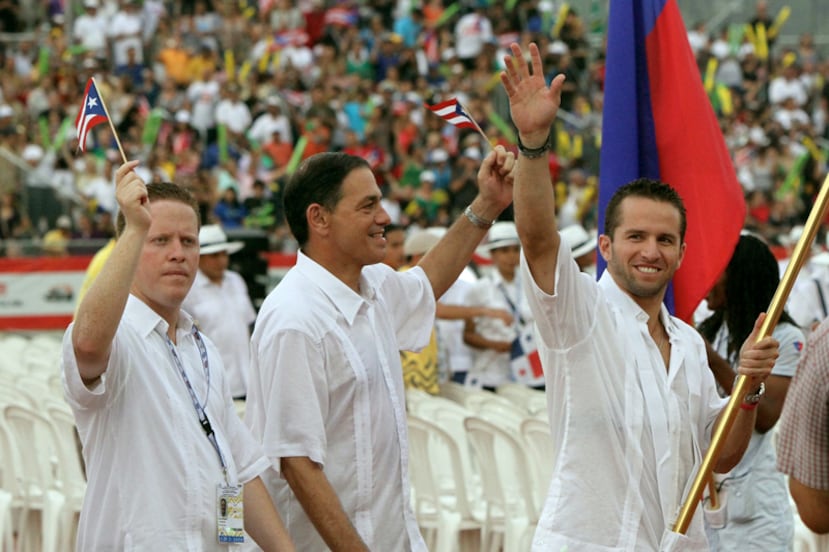 El entonces presidente del Comité Olímpico David Bernier, a la izquierda, junto al -en ese momento- Secretario de Recreación y Deportes Henry Newman y el abanderado por Puerto Rico, José Juan Barea.