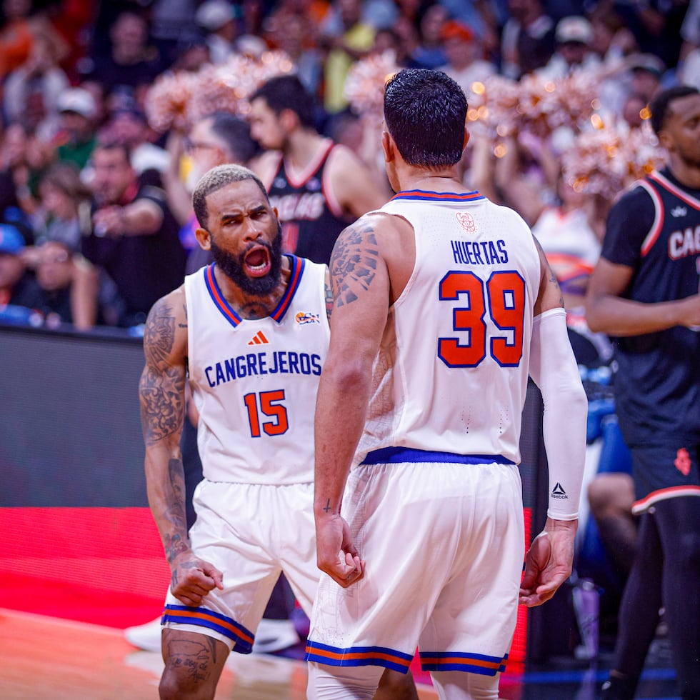 Walter Hodge Jr. y David Huertas celebran un canasto durante una victoria de los Cangrejeros de Santurce.