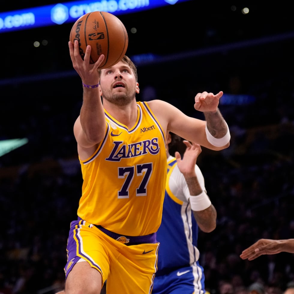 El estelar jugador de los Lakers de Los Ángeles, Luka Doncic, ataca el canasto frente al base de los Warriors de Golden State, De'anthony Melton.
