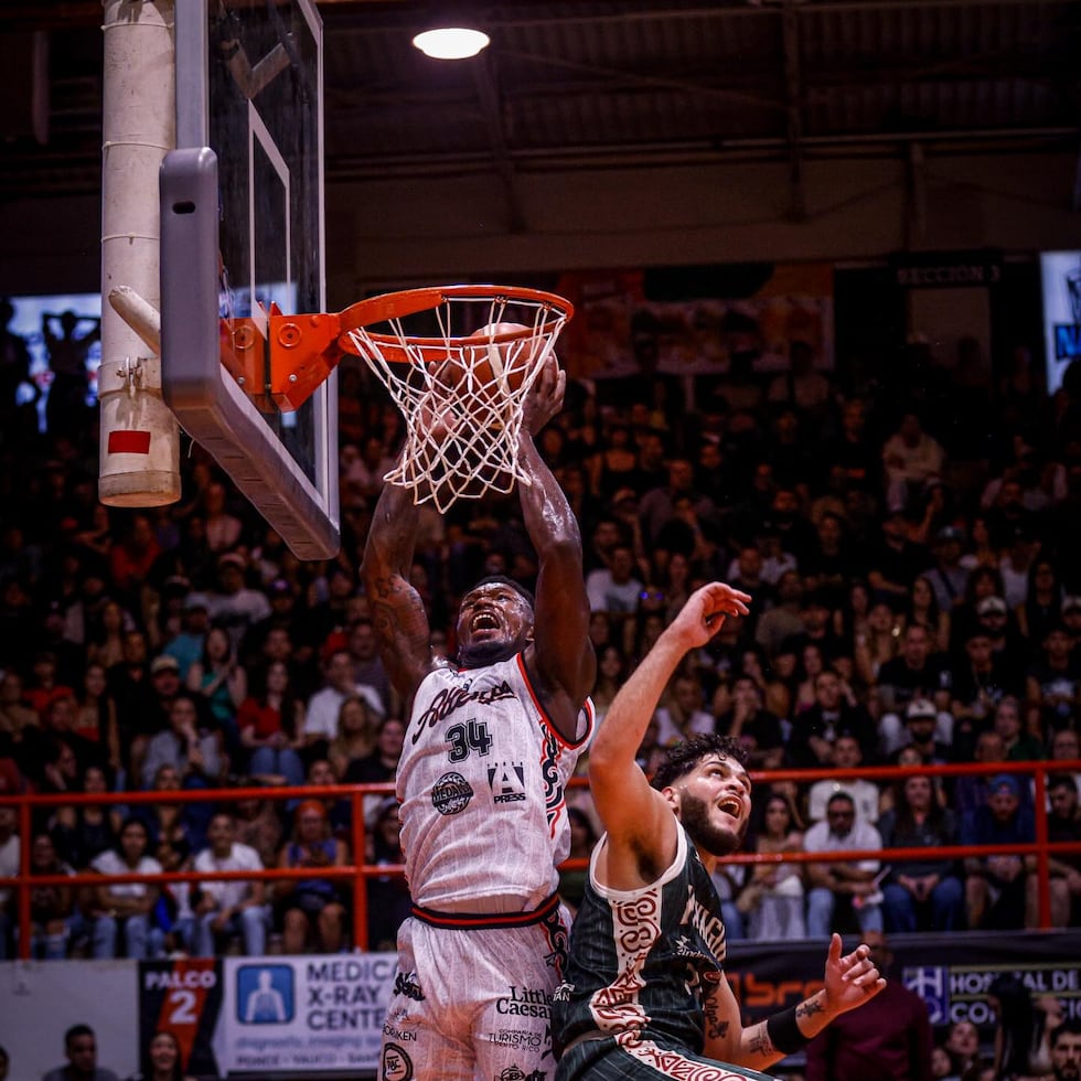 Nick Perkins, refuerzo de los Atléticos, donquea el balón contra los Indios.