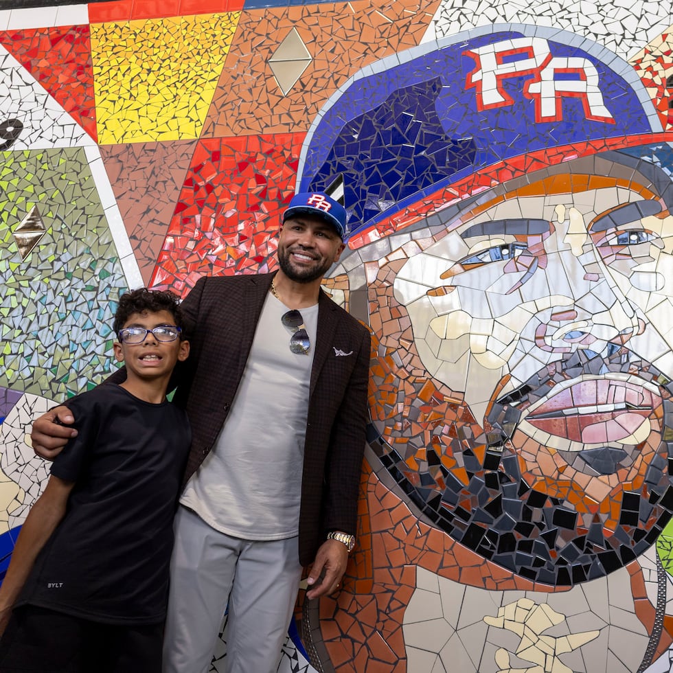 Carlos Beltrán, accompanied by his son, poses in front of his mosaic, which is part of the mural "Eternos" (Eternals), located in one of the corridors of Hiram Bithorn Stadium.