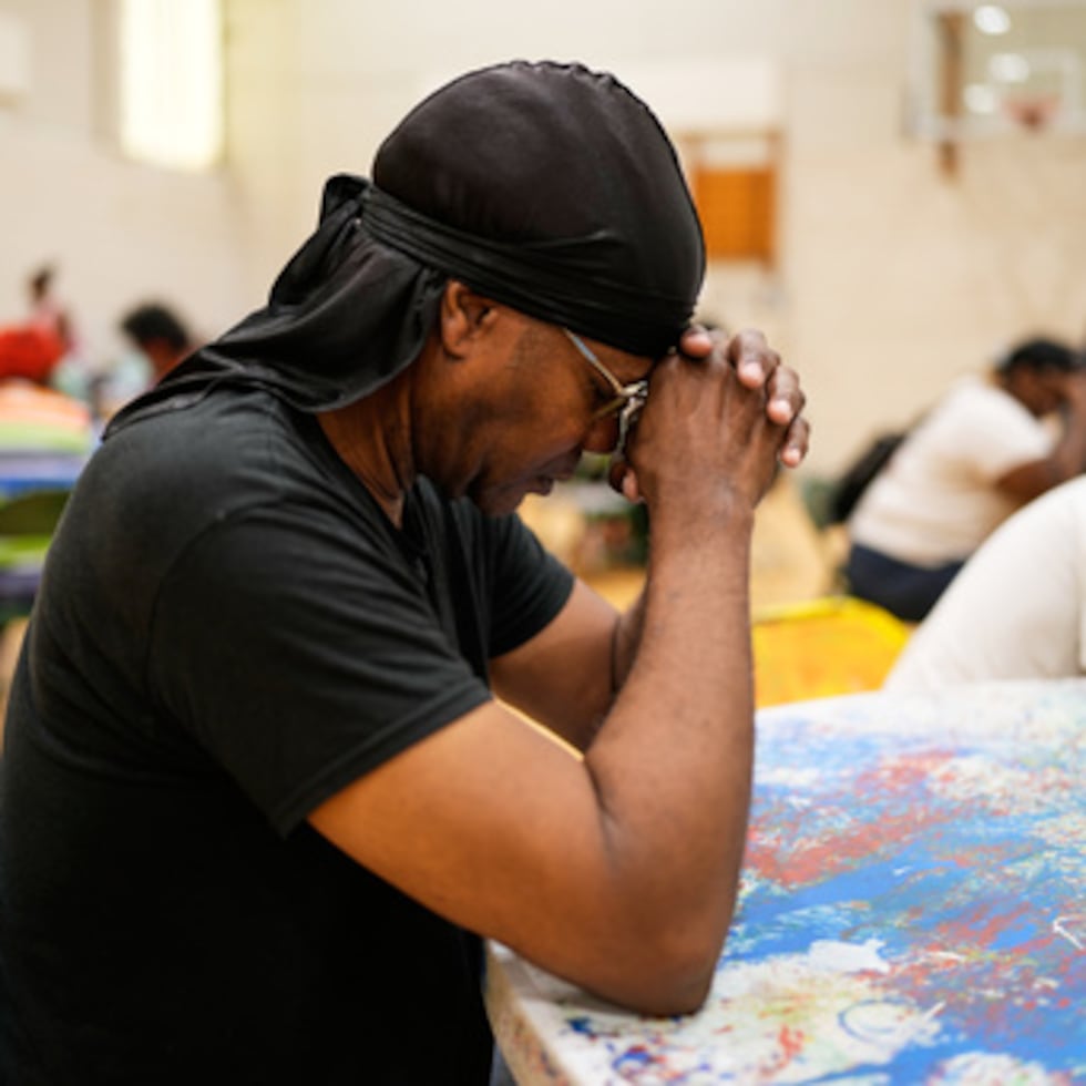 Una persona reza antes de recibir una comida para llevar gratuita en el City Life Center de Gary, Indiana, más de una semana después de que una tormenta mortal azotara la zona.
