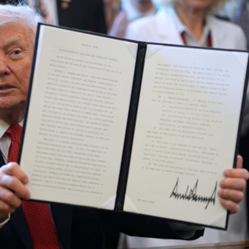 El presidente Donald Trump muestra una orden ejecutiva que reclasifica la marihuana como droga menos peligrosa en el Despacho Oval de la Casa Blanca, el jueves 18 de diciembre de 2025, en Washington. (AP Photo/Evan Vucci)