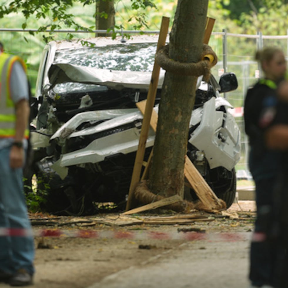 Se ve a varios policías junto a un vehículo que se ha estrellado contra un árbol tras arrollar a una multitud durante un acto de las fiestas del Orgullo en Berlín, Alemania, el domingo 26 de julio de 2026. (Foto AP/Markus Schreiber)