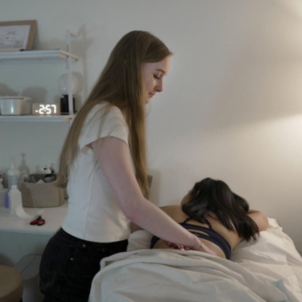 Zoë Armstrong, una paciente con endometriosis, descansa durante su sesión de fisioterapia del suelo pélvico con la fisioterapeuta Emma Codman —de pie— en Nueva York, el viernes 14 de agosto de 2026. (Foto AP/Shelby Lum)