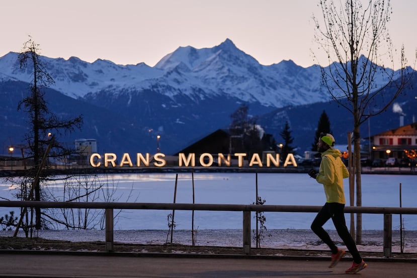 Un hombre corre a primera hora de la mañana en Crans-Montana, Alpes suizos, Suiza, el sábado 3 de enero de 2026, donde un devastador incendio en el bar Le Constellation dejó muertos y heridos durante las celebraciones de Año Nuevo. (Foto AP/Baz Ratner)