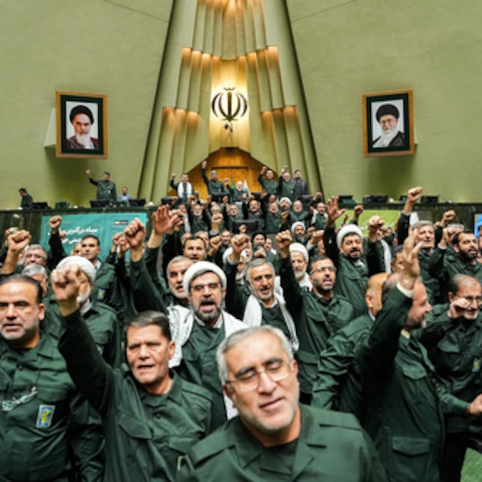 En esta foto difundida por la Agencia de Noticias de la Asamblea Consultiva Islámica (ICANA), legisladores iraníes corean consignas mientras visten el uniforme de la Guardia Revolucionaria.