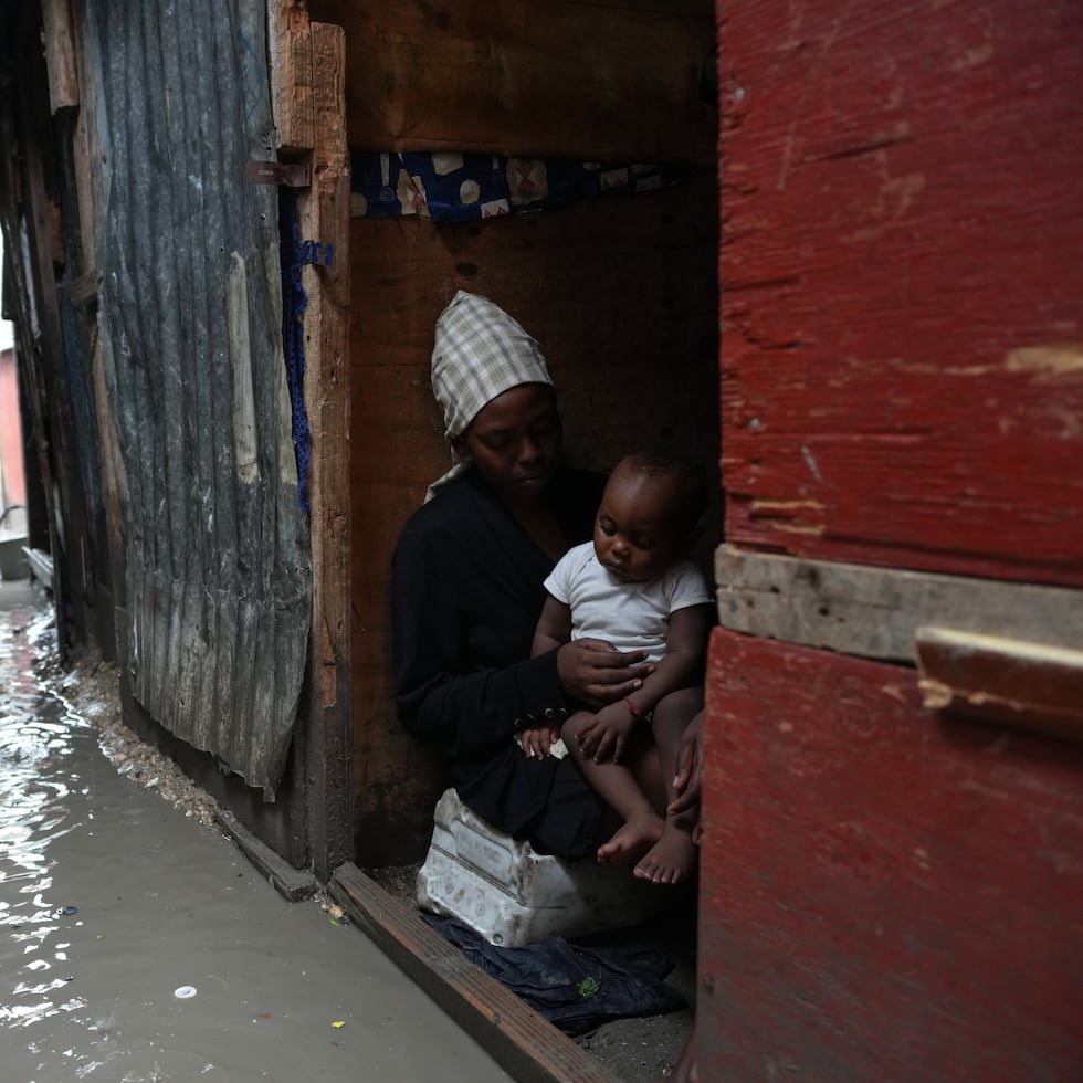 Personas dentro de un refugio para familias desplazadas por la violencia de las pandillas que se inundó por las lluvias provocadas por el huracán Melissa, en Puerto Príncipe, Haití, el miércoles 29 de octubre de 2025.