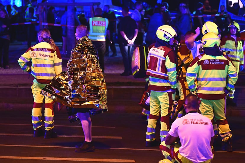 Una persona envuelta en una manta térmica permanece cerca del personal de emergencia tras la cancelación de las festividades del Día de Christopher Street en Berlín, el sábado 25 de julio de 2026. (Fabian Sommer/dpa/dpa vía AP)
