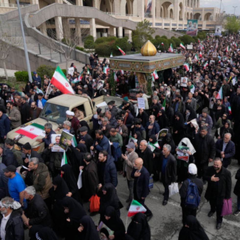 Gente sigue a un camión que lleva los ataúdes cubiertos con banderas del general Ali Mohammad Naeini, vocero de la Guardia Rrevolucionaria, y uno de sus camaradas del cuerpo paramilitar, Amir Hossein Bidi , en su cortejo fúnebre en Teherán.