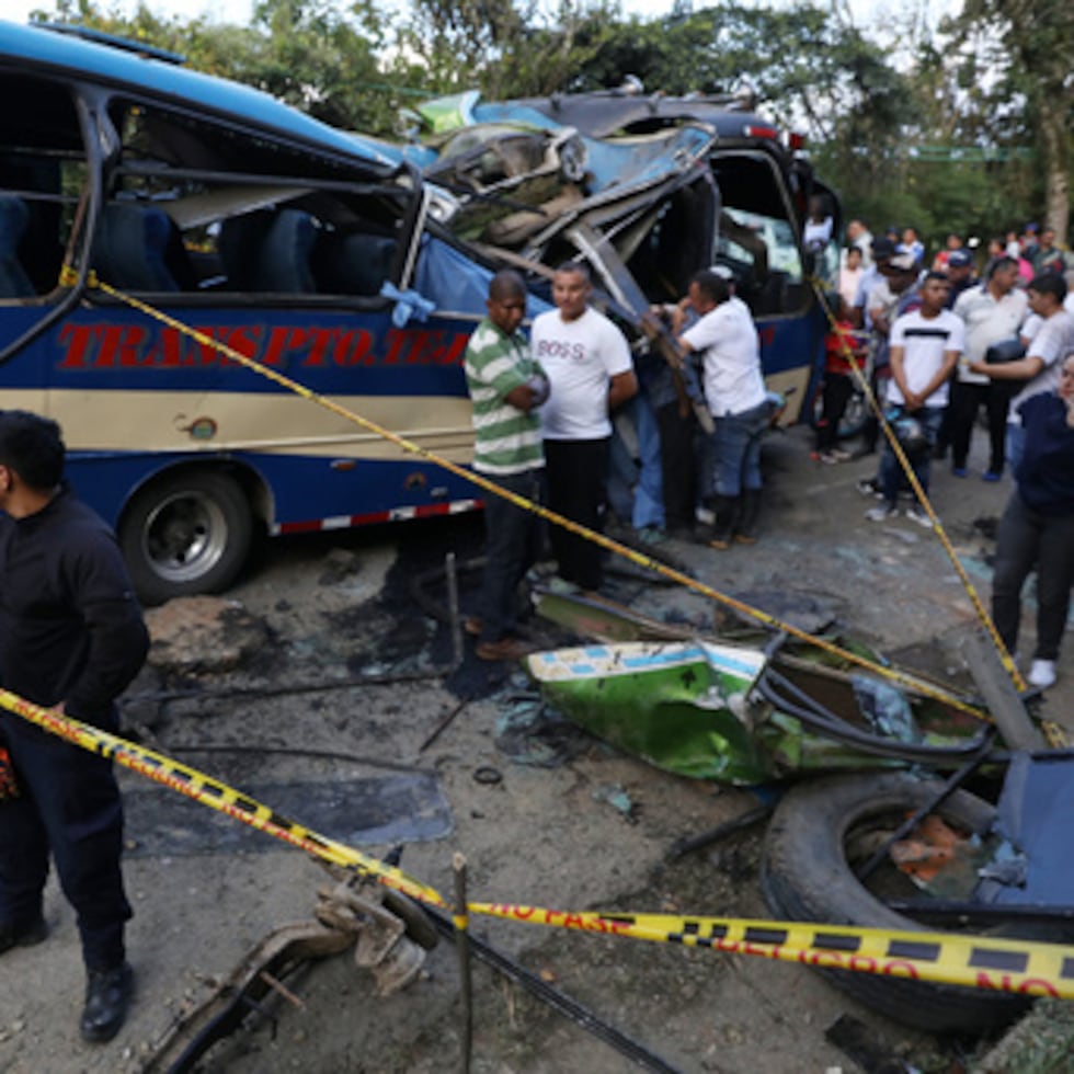 Un grupo de personas se congrega alrededor de un autobús que fue atacado con un artefacto explosivo en la vía Panamericana en el sector de El Túnel, en Cajibío, Colombia.
