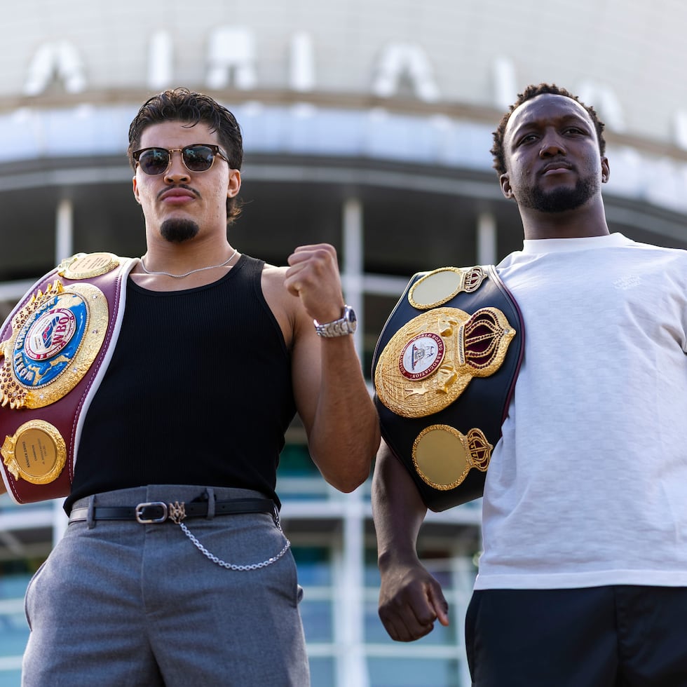 Xander Zayas and Abass Baraou pose with their respective titles outside the José Miguel Agrelot Coliseum.