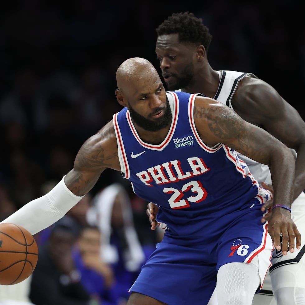 LeBron James defiende el balón frente a Julius Randle, de los Nets de Brooklyn, en un juego de pretemporada de la NBA.