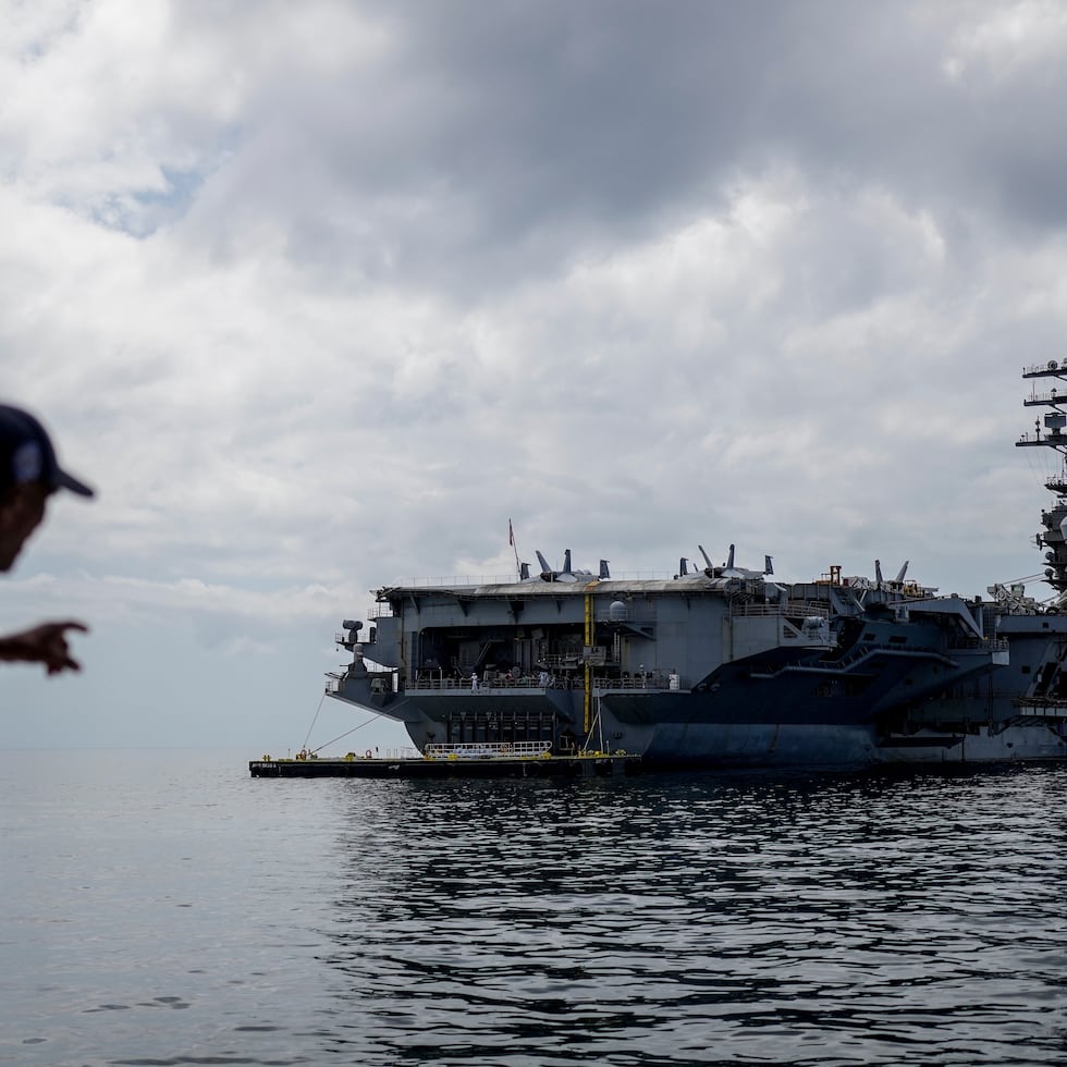 Un trabajador señala el portaaviones de la Armada estadounidense USS Nimitz atracando en el Golfo de Panamá, el lunes 30 de marzo de 2026.