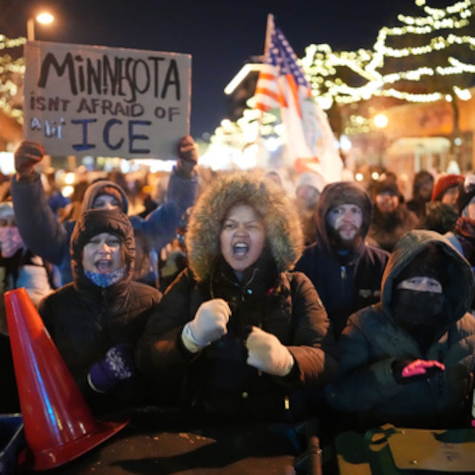 Manifestantes corean y golpean cubos de basura mientras permanecen detrás de una barricada improvisada durante una protesta en respuesta a la muerte de Alex Pretti, de 37 años, que fue abatido mortalmente por un agente de la Patrulla Fronteriza de EE.UU. a primera hora del día, el sábado 24 de enero de 2026, en Minneapolis. (AP Photo/Adam Gray)