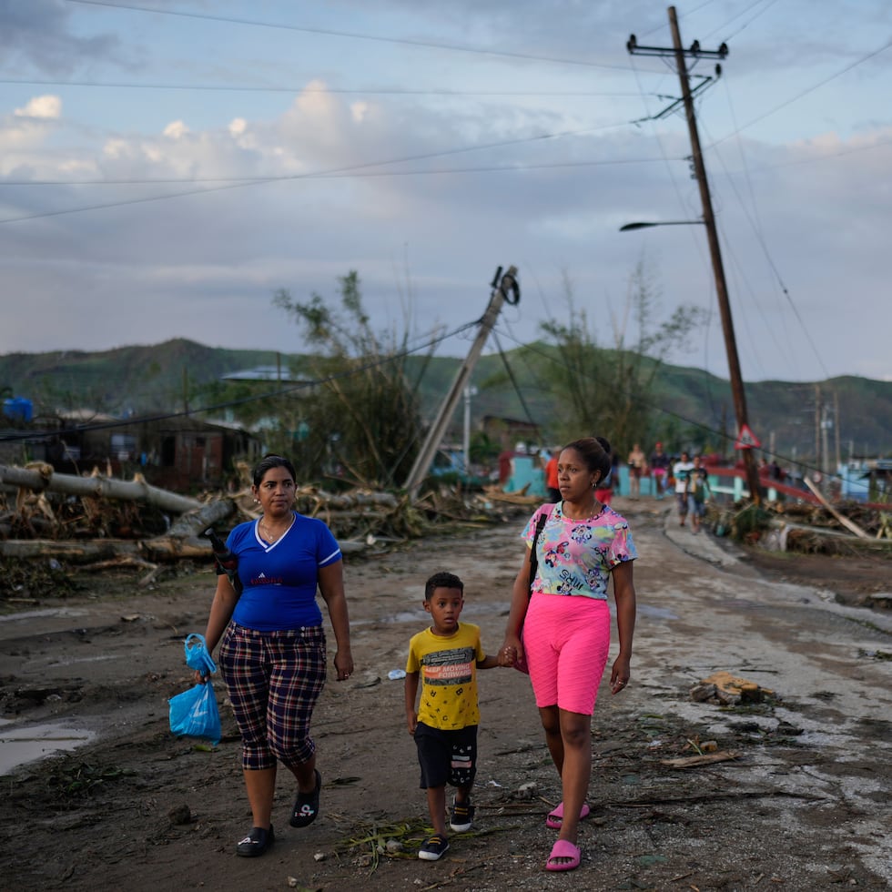 Residente de El Cobre, Cuba, caminan entre la destrucción causada por el huracán Melissa.