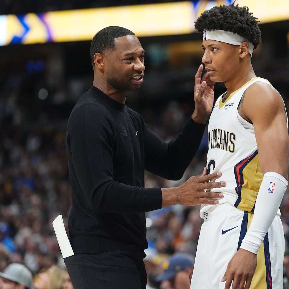Willie Green, dirigente de los Pelicans de Nueva Orleans, a la izquierda, habla con el base Jeremiah Fears, al centro, mientras el entrenador asistente James Borrego observa en la primera mitad de un juego de baloncesto de la NBA contra los Nuggets de Denver el miércoles 29 de octubre de 2025, en Denver. (AP Photo/David Zalubowski)