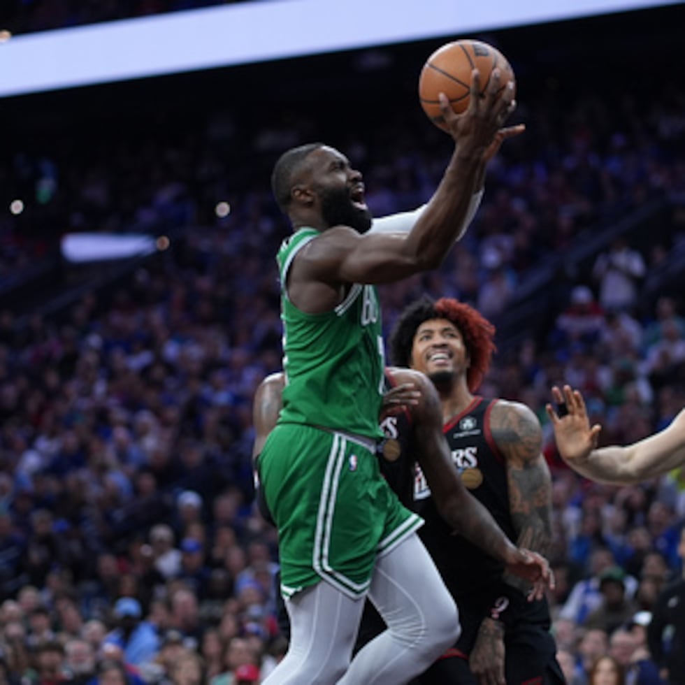 Jaylen Brown (izq.), de los Boston Celtics, se lanza a canasta ante Kelly Oubre Jr., de los Philadelphia 76ers, durante la primera mitad del tercer partido de la primera ronda de los playoffs de baloncesto de la NBA, el viernes 24 de abril, en Filadelfia.