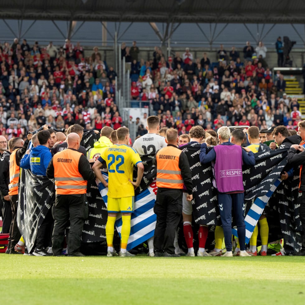 Jugadores de Dinamarca y Ucrania forman un círculo alrededor del jugador danés Christian Eriksen después de que se desplomara durante el partido amistoso internacional de fútbol entre Dinamarca y Ucrania en Odense, Dinamarca.