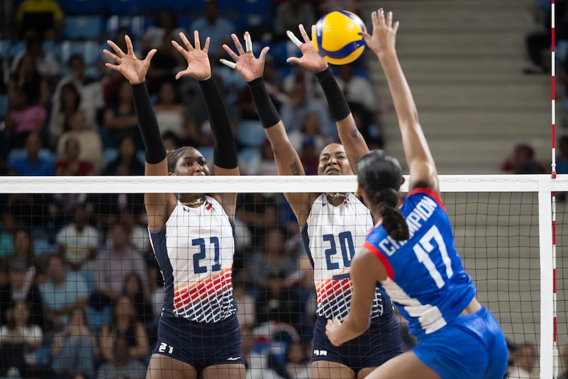 Brayelin Martínez y Jinery Martínez bloquean un ataque de Deselice Champion.