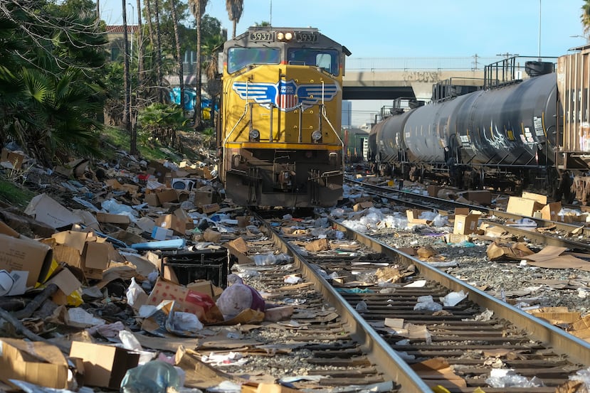 Cajas y paquetes rotos pueden verse en una sección de las vías del tren de Union Pacific, el viernes 14 de enero de 2022, en el centro de Los Ángeles.