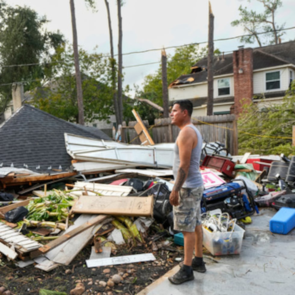 José Rosas inspecciona los daños en la casa de Guillermo Vargas mientras ayuda a limpiar los daños de la tormenta en la subdivisión Memorial Northwest, en Spring, Texas, el lunes 24 de noviembre de 2025.