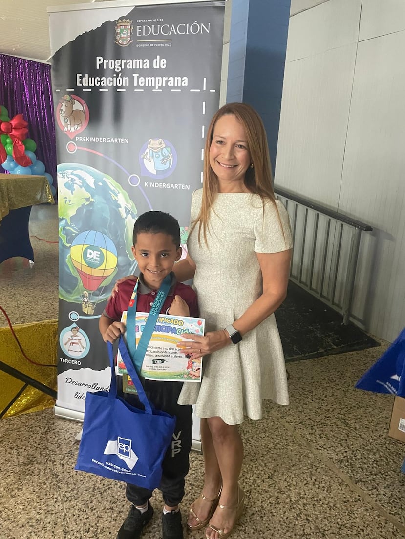Airam Ariel Maldonado Rosario, estudiante de segundo grado de la Escuela Violeta Reyes Pérez, en Cidra, y miembro del Club Mi Librito, posa junto a la maestra Hecmary Vázquez luego de ganar el primer lugar a nivel isla, en la categoría de primero a segundo grado, del Certamen Literario “Había una vez en Puerto Rico”, organizado por el Departamento de Educación.