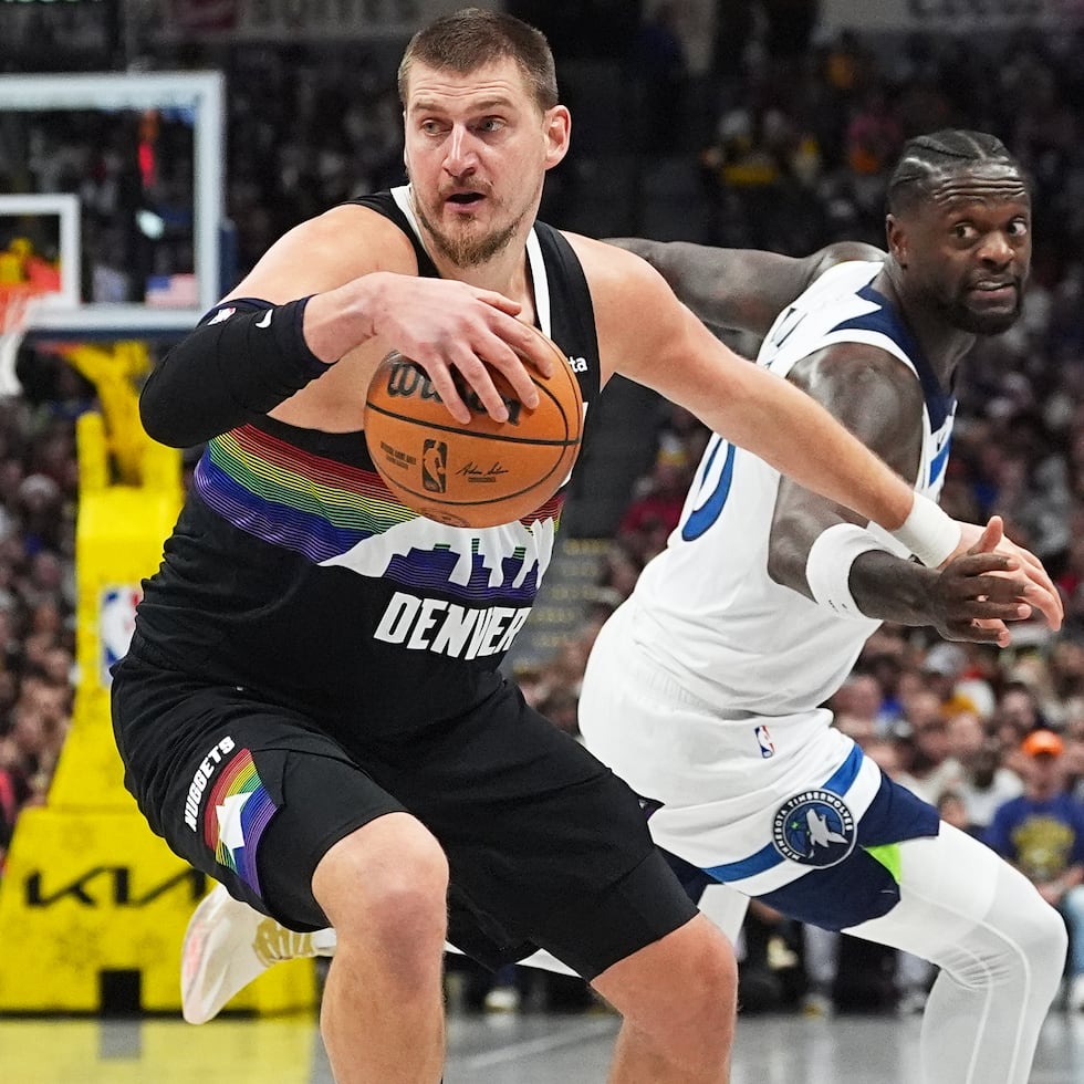 Nikola Jokic, de los Nuggets, se le escaba a la defensa de Julius Randle, de los Timberwolves de Minnesota.