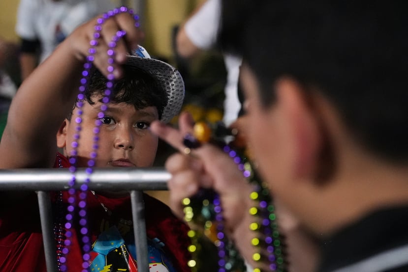 Xander Ricardo, de 7 años, reparte cuentas y otros regalos a los nicaragüenses que visitan el altar de su familia dedicado a la Virgen María, durante las celebraciones de la Inmaculada Concepción, el 8 de diciembre, en la iglesia católica de San Juan Bosco, el domingo 7 de diciembre de 2025, en Miami. (Foto AP/Rebecca Blackwell)