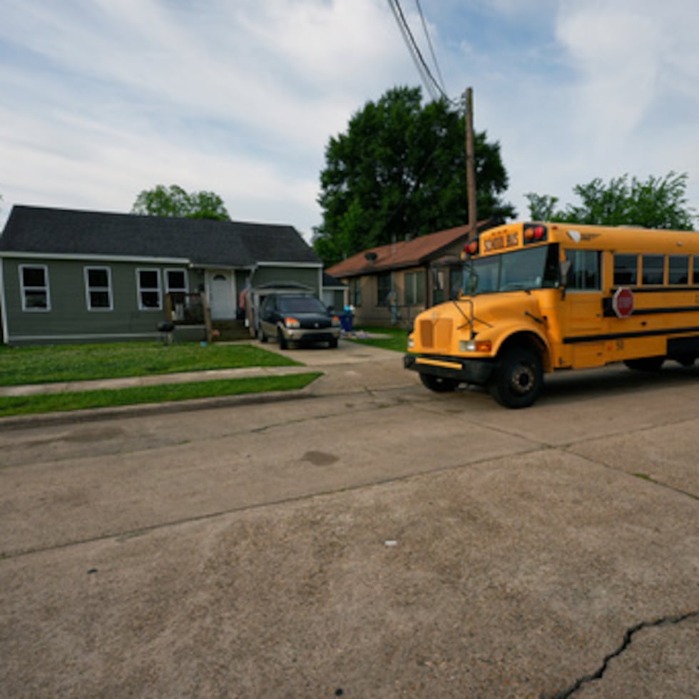 Un autobús escolar pasa por la casa donde 8 niños fueron asesinados durante un tiroteo masivo el día anterior en Shreveport, La., Lunes, 20 de abril 2026. (AP Photo/Gerald Herbert)