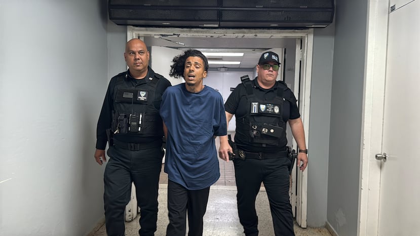 Agentes de la Policía Municipal de San Juan trasladan al Cuartel General de la Policía de Puerto Rico a uno de los detenidos tras el asesinato de un turista en el Viejo San Juan.