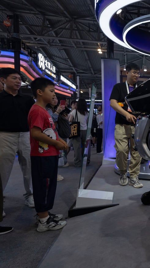 Un hombre monta un robot de DaxRobotics, una empresa emergente china de inteligencia artificial y robótica
