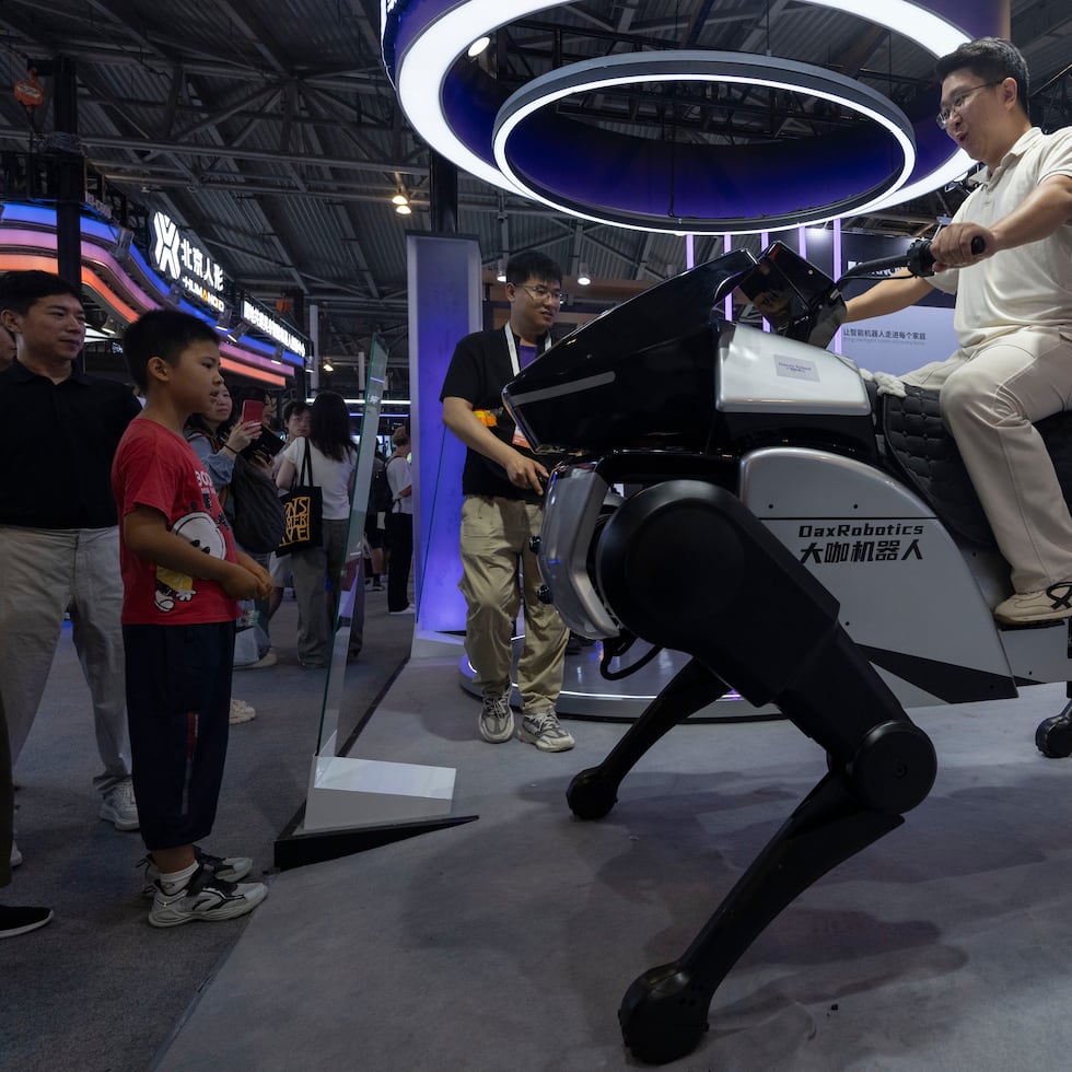 Un hombre monta un robot de DaxRobotics, una empresa emergente china de inteligencia artificial y robótica