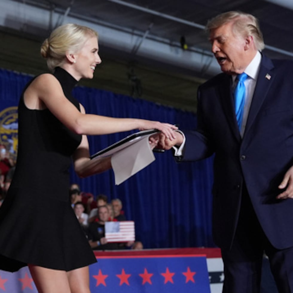 El presidente Donald Trump entrega una orden ejecutiva firmada a la asesora de la Casa Blanca Natalie Harp durante un mitin de campaña celebrado en el Pinnacle Bank Expo Center, el lunes 5 de octubre de 2026, en Grand Island, Nebraska. (Foto AP/Alex Brandon)