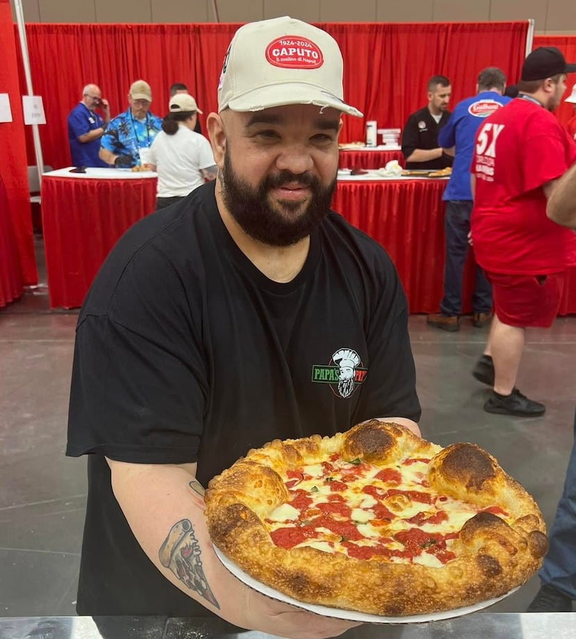 El puertorriqueño Wilhelm Rodríguez Flores sostiene en sus manos la pizza que lo llevó a la fase final de la competencia de mejor pizza tradicional dentro de la competencia International Pizza Challenge.