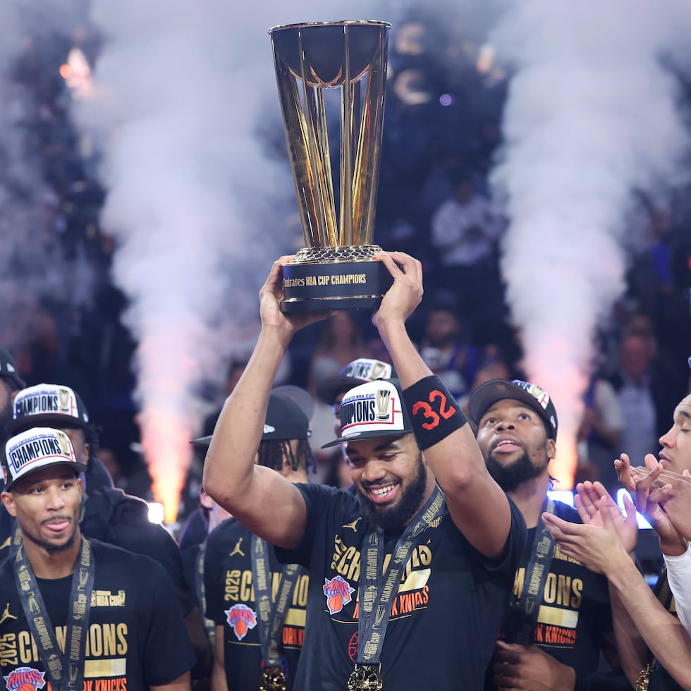 El centro de los Knicks Karl-Anthony Towns (32) alza el trofeo de la Copa de la NBA.