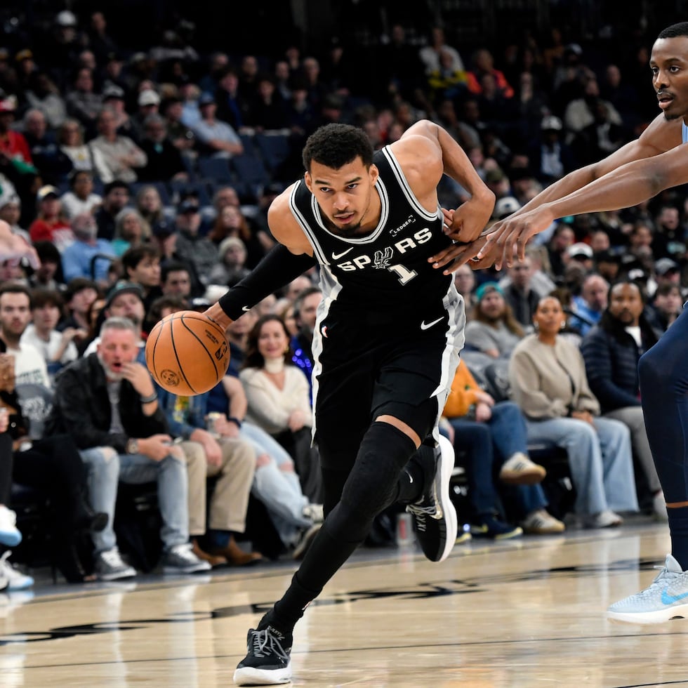 Victor Wembanyama, de los Spurs, avanza hacia el canasto ante el intento defensivo de Christian Koloko, de los Grizzlies, por detenerlo.